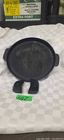 Top view of round cast iron grill pan with two silicone handle protectors in front