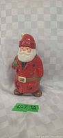 Front view of ceramic Santa tealight holder showing painted details and star cutouts