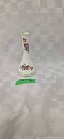 Front view of white Oakley China bud vase with floral motif and gold rim