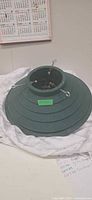 Overall view of green plastic tree stand on cloth
