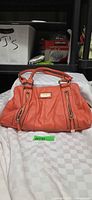 Full view of orange Fiorelli leather handbag