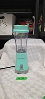 Front view of Hamilton Beach mint green personal blender showing base, jar and lid