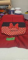 Front view of Minnie Mouse cosmetic bag showing bow graphic and polka-dot design