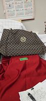 Front view of brown patterned shoulder bag showing M logo