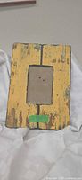 Front view of distressed yellow wooden frame