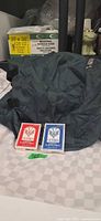 Two Victoria playing card decks and dark green nylon camping bag
