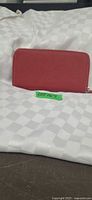 front view red leather wallet standing upright on white surface