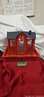 front view red steel birdhouse on tray