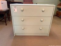 Front view of three-drawer Ikea chest painted light green with round knobs