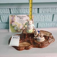 Front view of stump display with both figurines and tape measure for scale