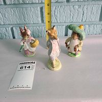 All three Beswick Beatrix Potter figurines with tape measure indicating height
