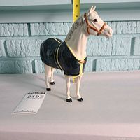 Full side profile of Beswick pony figurine with measuring tape for scale