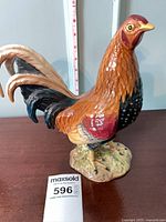 Profile view of Beswick ceramic gamecock figurine next to ruler showing 9.5 in height