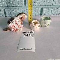 Group shot: beaver paperweight, gold medallion pot, green mustard dish with measuring tape for scale