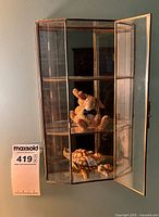 Glass trinket cabinet with figurines inside