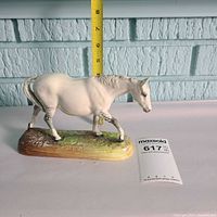 Full left side view of Royal Doulton horse figurine with tape measure and scale for size reference
