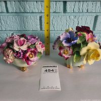 Both bone china floral figurines side by side with ruler for scale