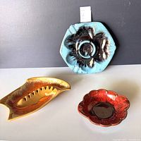 All three ceramic ashtrays grouped together
