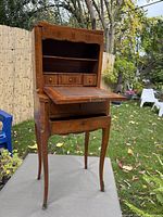 Front view open showing interior drawers, shelves, and leather writing surface