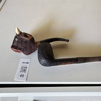 Full view of carved bull head pipe showing stem and bowl