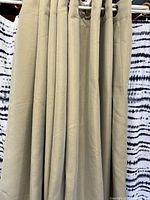 Full view of beige blackout curtain panels hanging on rod