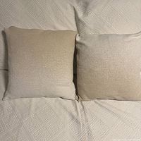 Two square ombre cushions on patterned bedding
