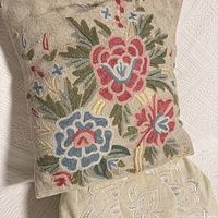 Front view of floral tapestry cushion and top of cream meditation pillow