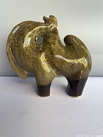 Front view of mottled brown stoneware camel sculpture