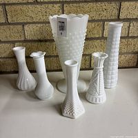 Group shot of six milk glass vases