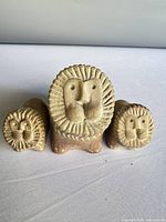 front view of three soapstone lion figurines