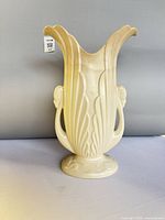 Front view of cream Beswick swan vase showing stylized handles, flared rim, feather relief