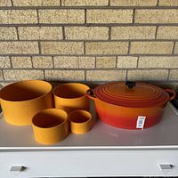 Dutch oven and four yellow bowls on surface