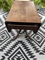 Table with leaves down showing drawer and pedestal base