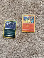 Front view of Charizard and Umbreon cards on carpet