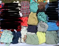 Folded assortment of 3T clothes including shirts, shorts, pants, dress and skirt
