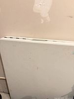 Folded white plastic 6 ft table showing carry handle and surface marks