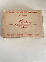 Outer cardboard sleeve with Ambassador branding, globe logo, 1848-1967, cities listed
