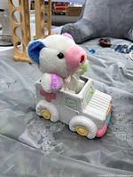 Full view of plush bear sitting in decorative ambulance