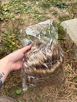 Hand holding clear plastic bag filled with assorted faux fur fabric squares