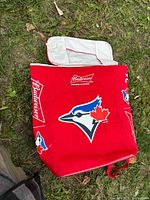 Full view of red insulated cooler tote with Blue Jays logo and Budweiser branding, zipper open showing insulated lining