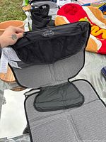 Full view of Summer brand car seat protector opened to show upper mesh pockets and lower padded section