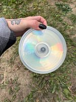 Hand holding spindle showing top disc labelled DVD-R