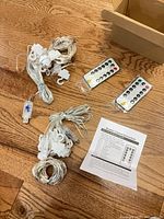 Two coiled LED curtain lights with hooks, two remotes, instructions, open box