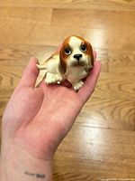 Front view of porcelain basset hound figurine in hand