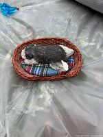 Top view of dog figurine on basket bed showing design and plaid cushion
