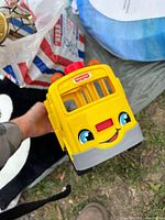 Front view of yellow Fisher-Price school bus with smiling face graphic