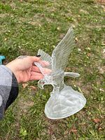 Oblique view of glass eagle figurine showing front and left side details