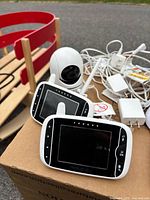 Overall view showing two monitors, one camera, multiple power adapters and cables