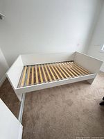 Overall view of white single bed frame showing slatted base