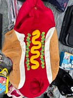 Plush hot dog costume with tan bun, red interior, yellow mustard and green relish appliqué